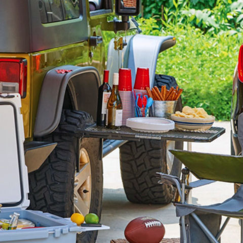 The Original Tailgater Tire Table on Jeep table with food and drinks